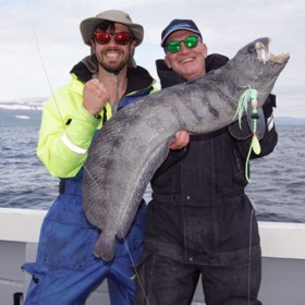 Zwei Angler präsentieren einen geangelten Fisch Zwei Angler präsentieren einen geangelten Fisch