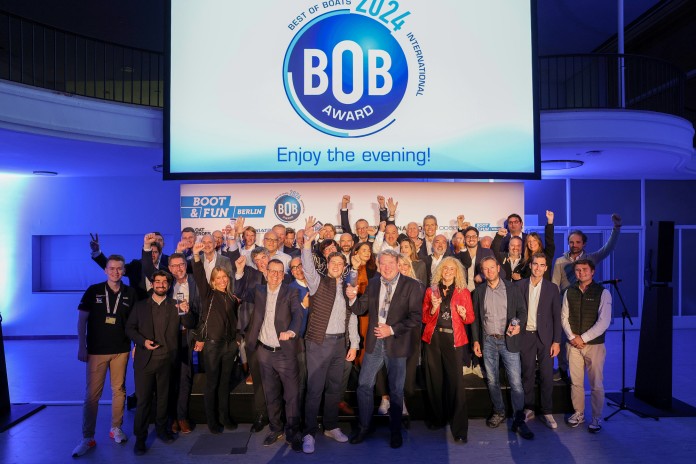A group of people standing on a stage, some of them are holding an award.