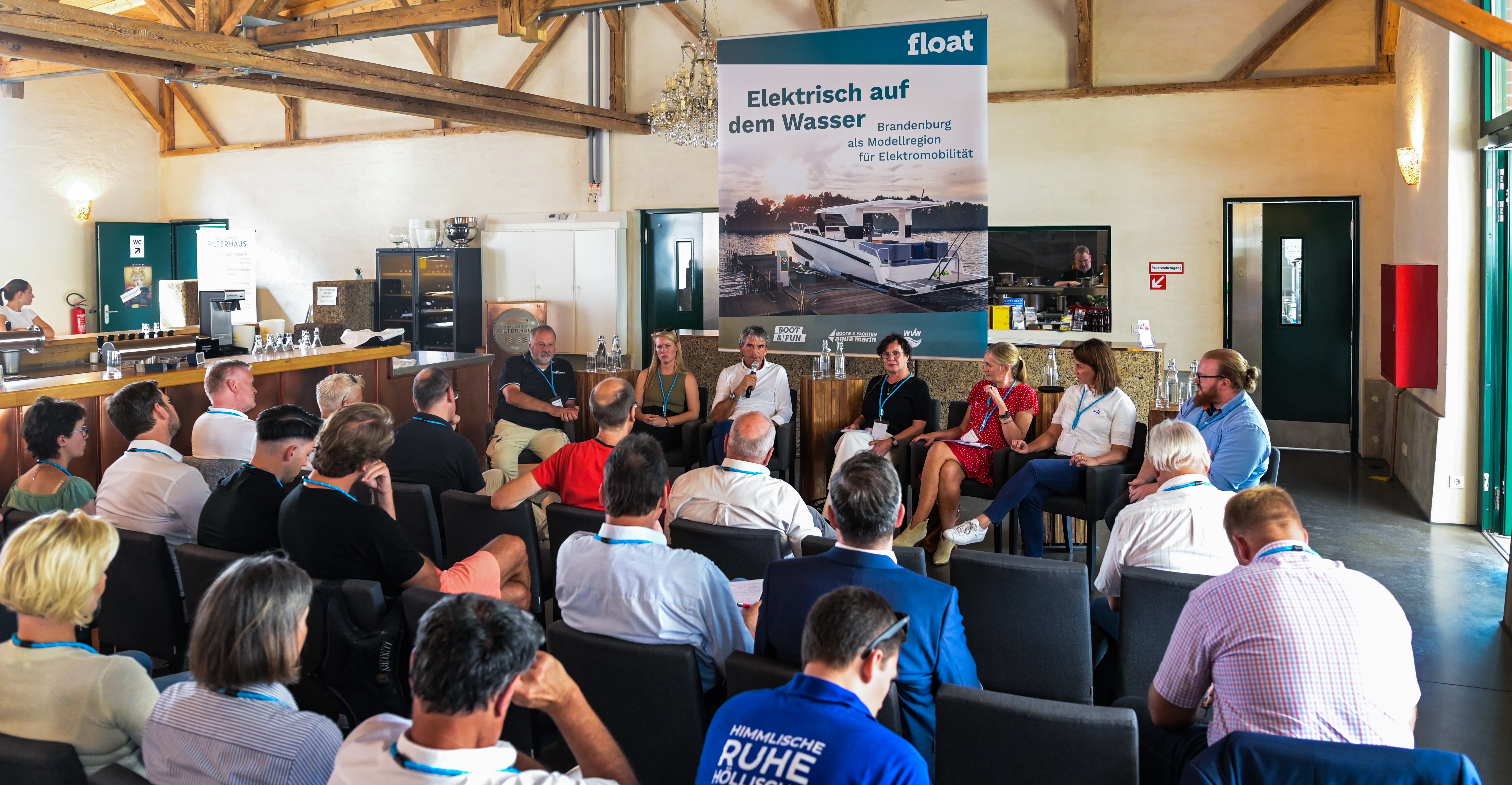 Erster Electric Summit im Filterhaus in Werder (Havel): Vertreter:innen von Werften, Hersteller, Wissenschaft diskutieren aktuellen Stand zur Elektromobilität auf dem Wasser vor gut besuchtem Haus.