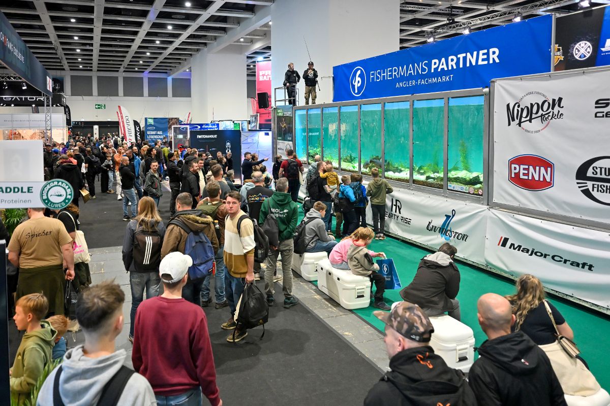 Messebesucher stehen in der Halle der Angelwelt und betrachten ein XXL-Aquarium.